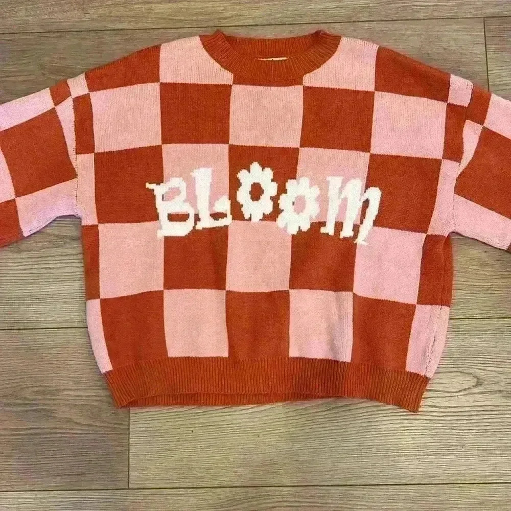 Pink and orange blocked women’s size medium sweater with the word bloom on front